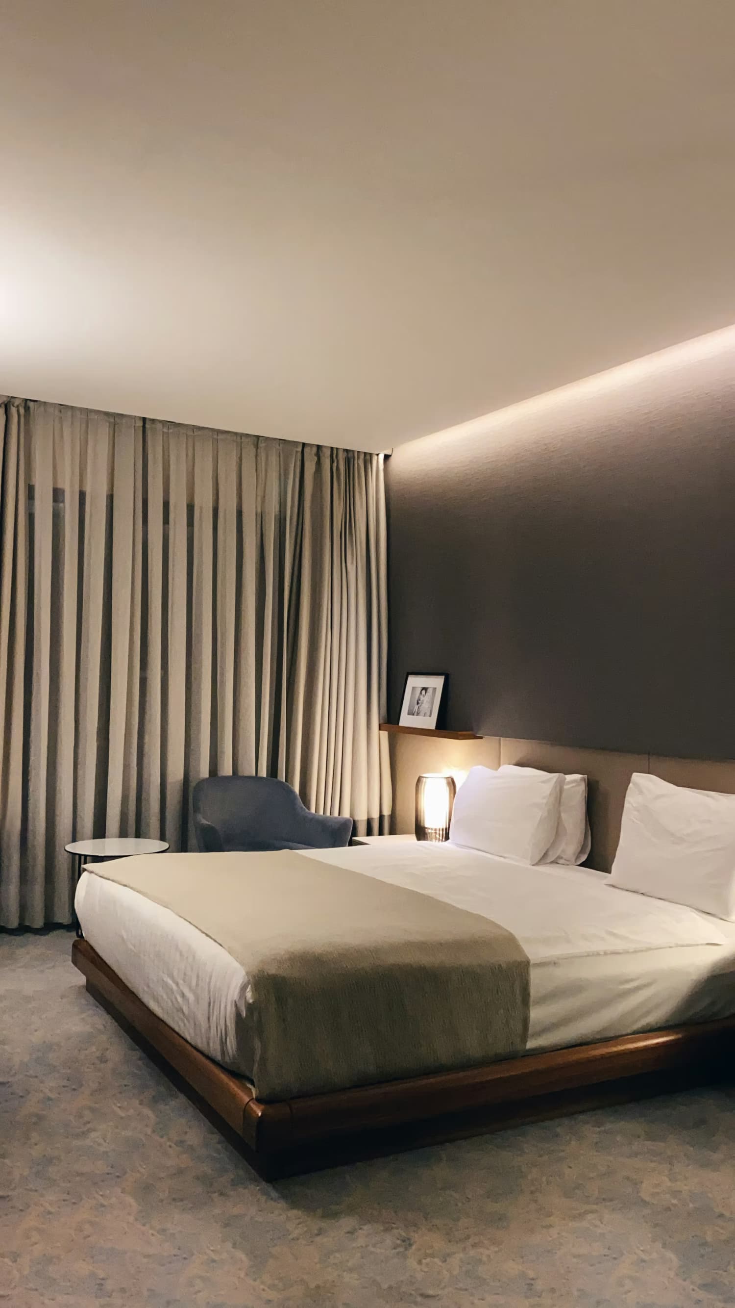 Een donkere hotelkamer met een tweepersoonsbed