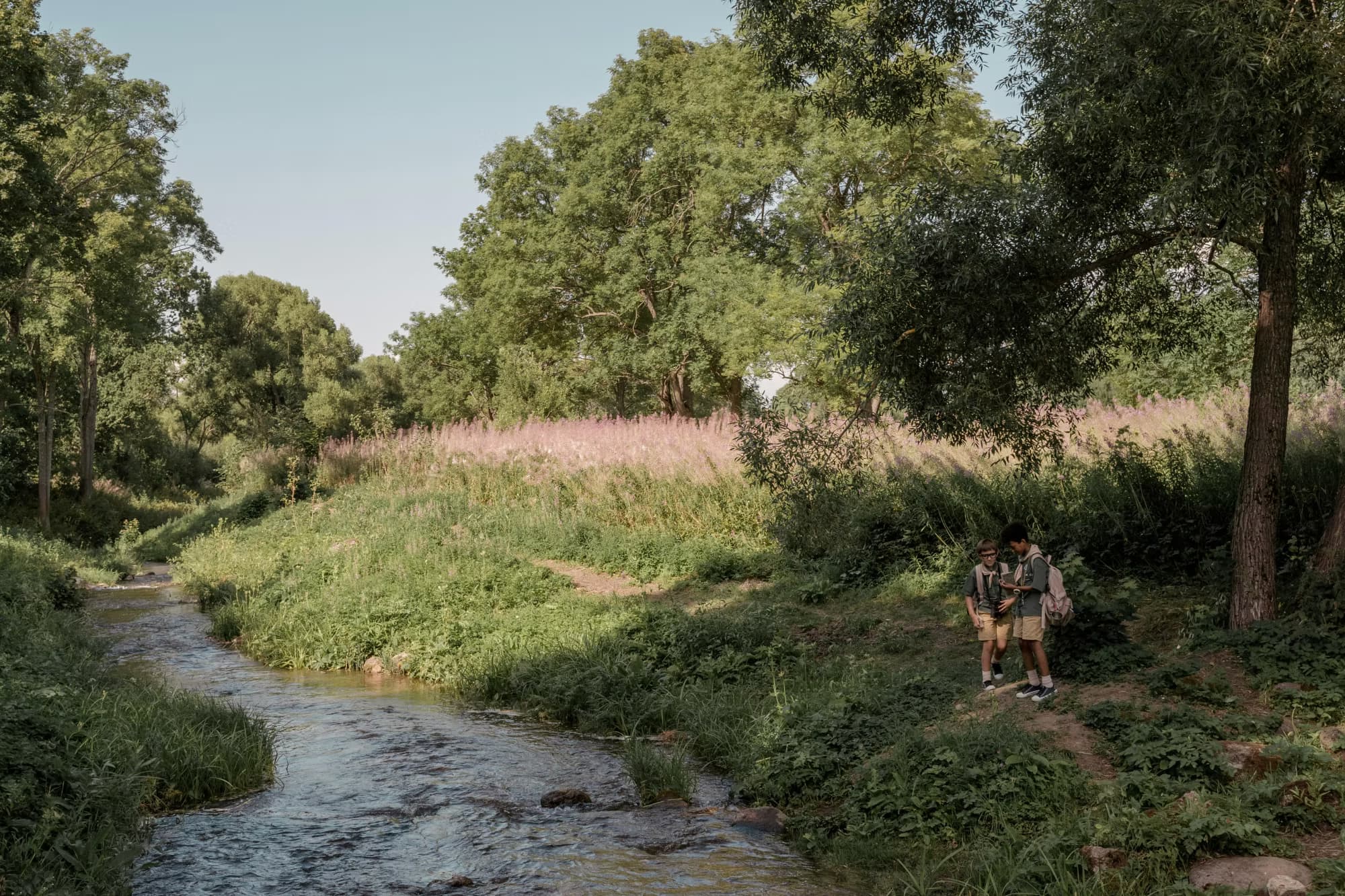 Twee scoutsjongens staan in een bos